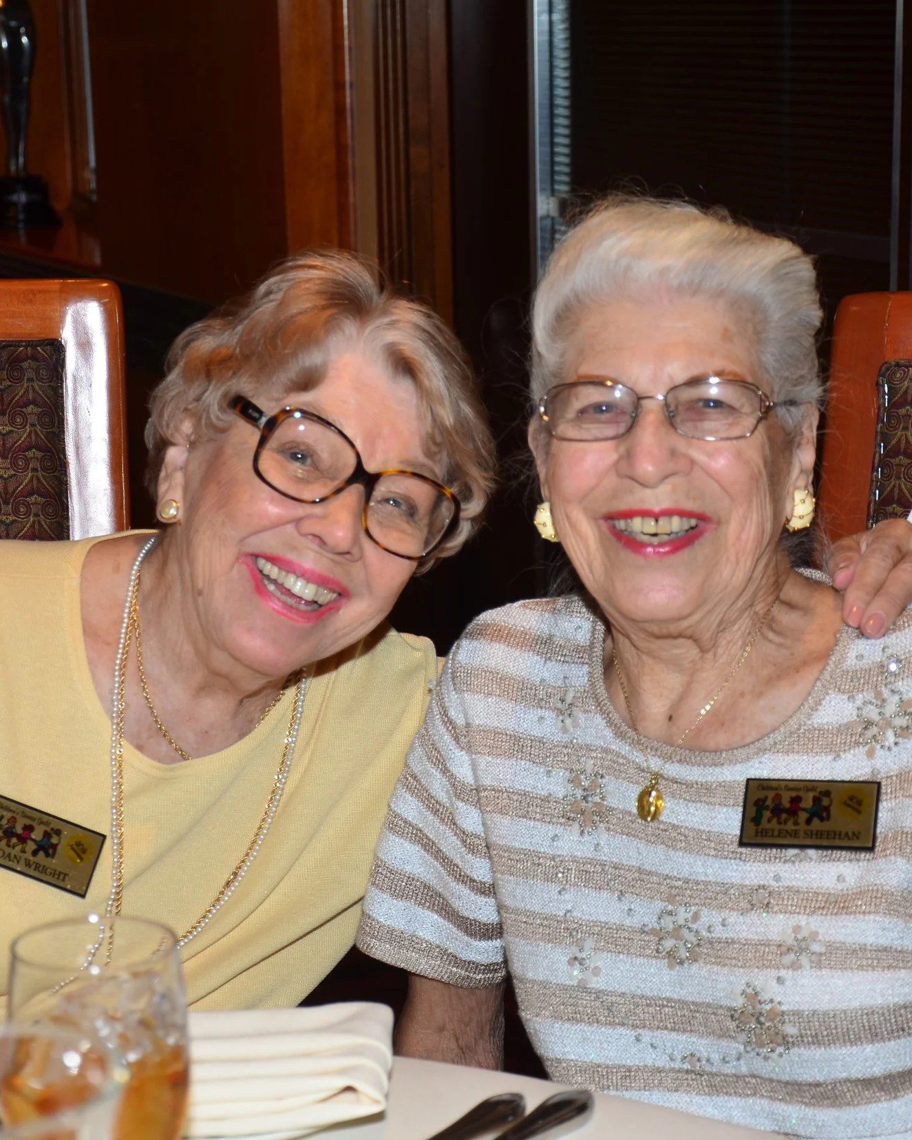Two smiling elderly women sitting together.