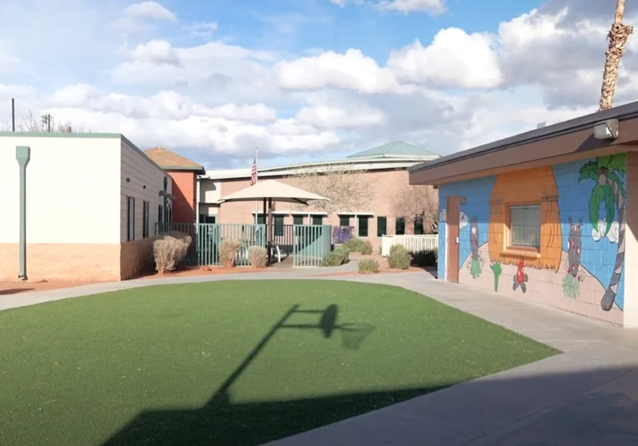 School courtyard with mural and artificial grass.