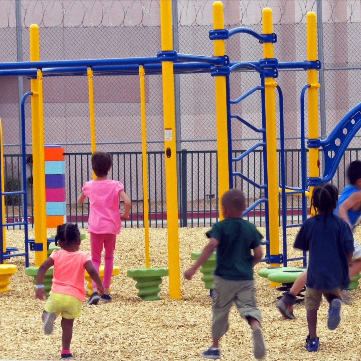 Children playing on colorful playground equipment.